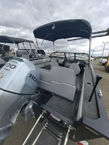 Slide: The Image of 2022 Starweld 19' FLEX DC boat with Honda engine, docked under cloudy skies. - 2
