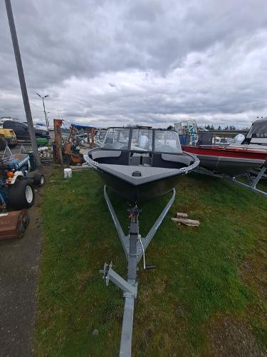 Slide: The Image of 2022 Starweld 19' FLEX DC boat on a trailer, parked on grass under cloudy skies. - 5