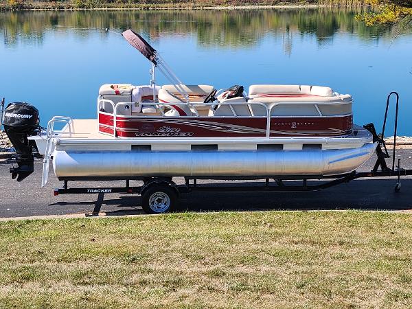 Slide: The Image of 2012 Sun Tracker Party Barge 20 DLX pontoon boat on trailer by a lake. - 0