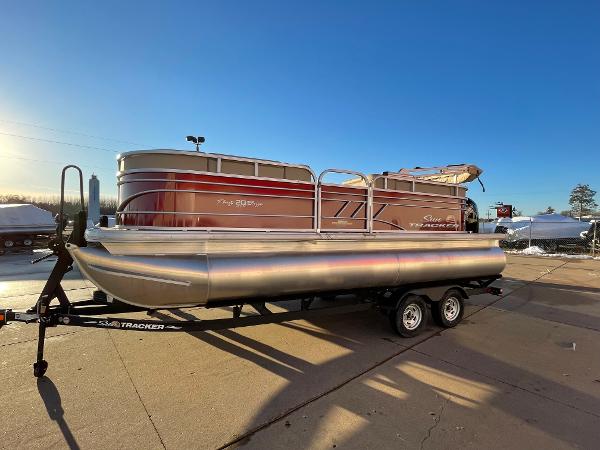 Slide: The Image of 2024 Sun Tracker Party Barge 20 DLX pontoon boat on trailer in outdoor setting. - 0