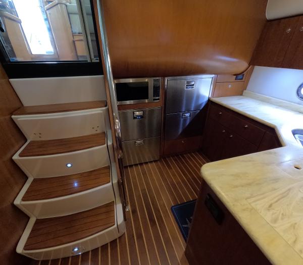 Slide: The Image of 2004 Tiara Yachts 5200 Sovran Salon kitchen with wooden flooring and stainless steel appliances. - 11