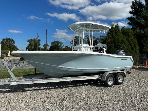 Slide: The Image of 2024 Tidewater 210 CC Adventure boat on a trailer under a clear blue sky. - 1