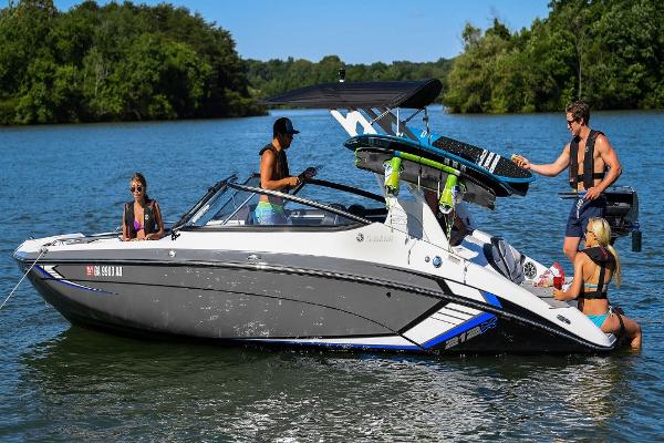 Slide: The Image of 2023 Yamaha Boats 212X on a lake with people enjoying water activities. - 0