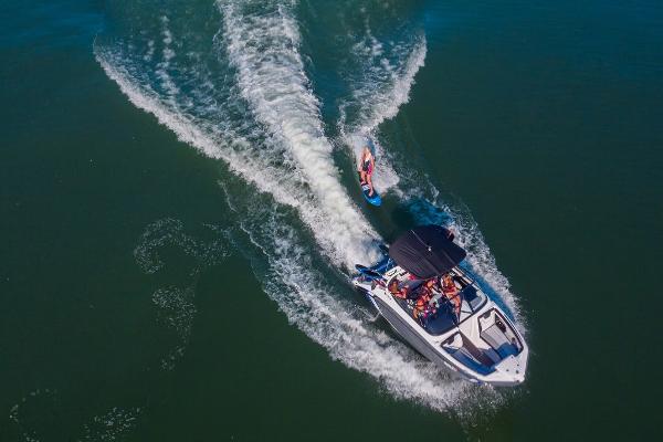 Slide: The Image of 2023 Yamaha Boats 212X towing a wakeboarder on a lake. - 4