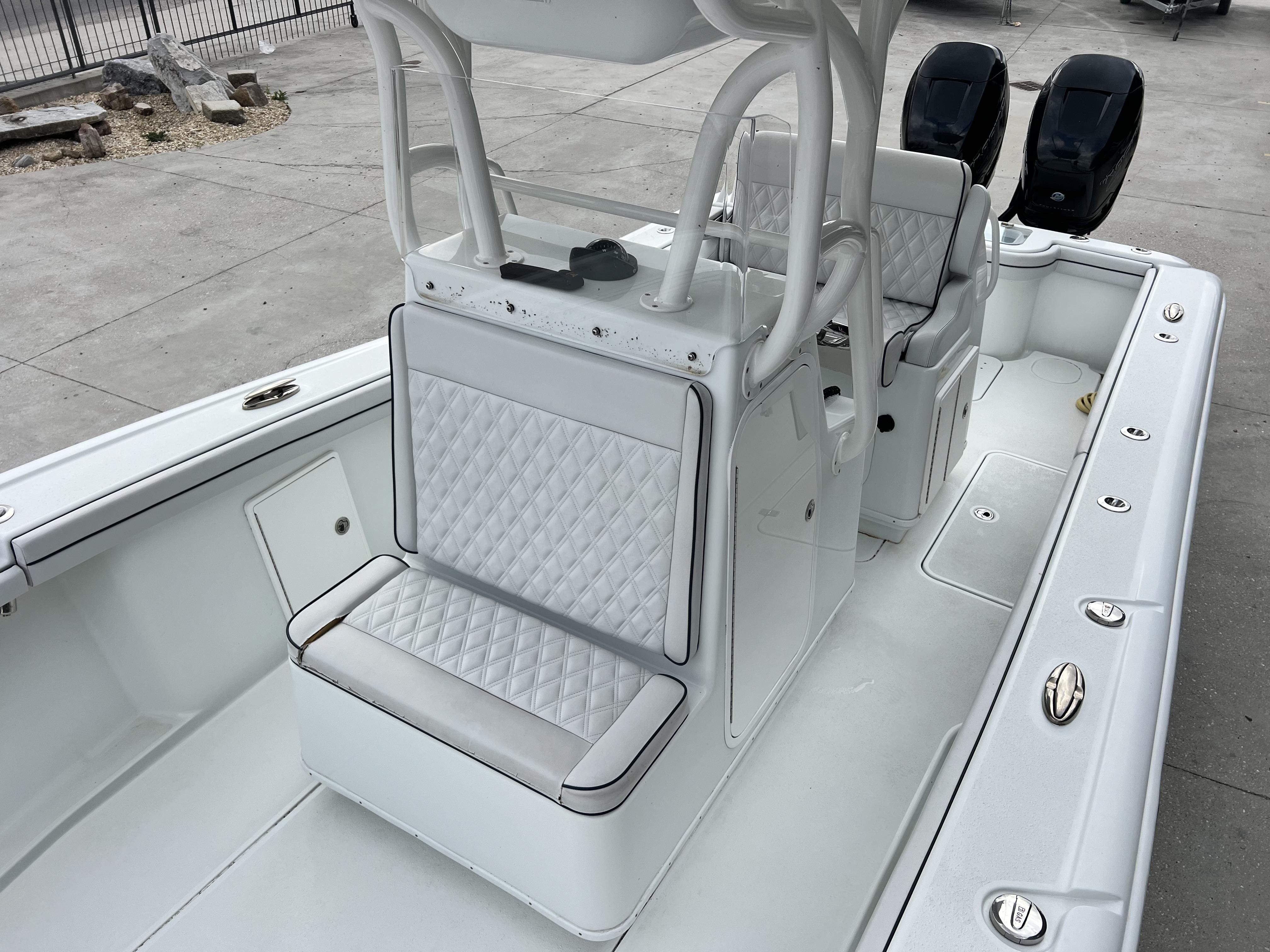 Slide: The Image of 2018 Yellowfin 29 boat interior with white diamond-stitched seating and dual outboard motors. - 10