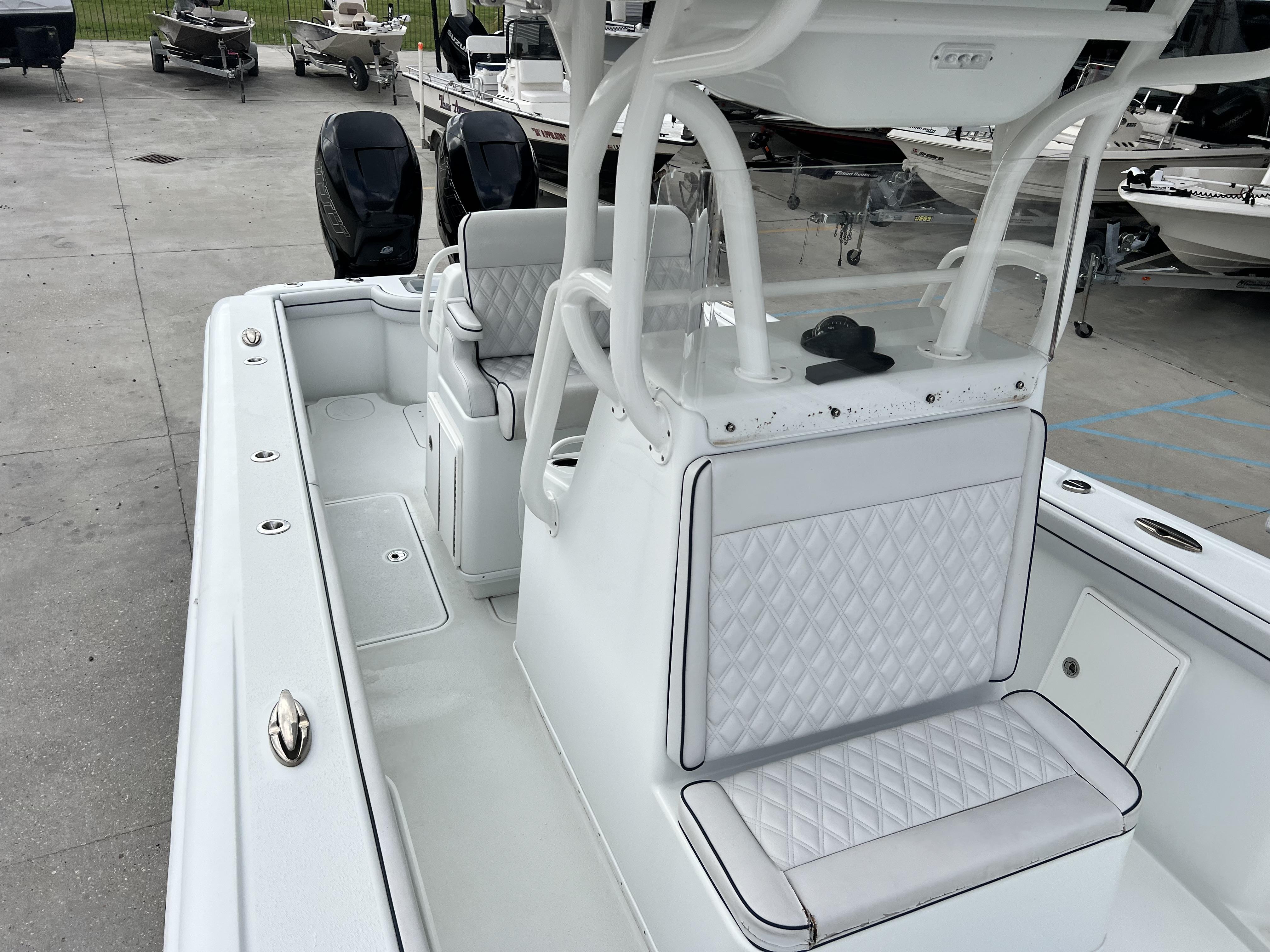 Slide: The Image of 2018 Yellowfin 29 boat interior with dual outboard motors and white diamond-stitched seating. - 11