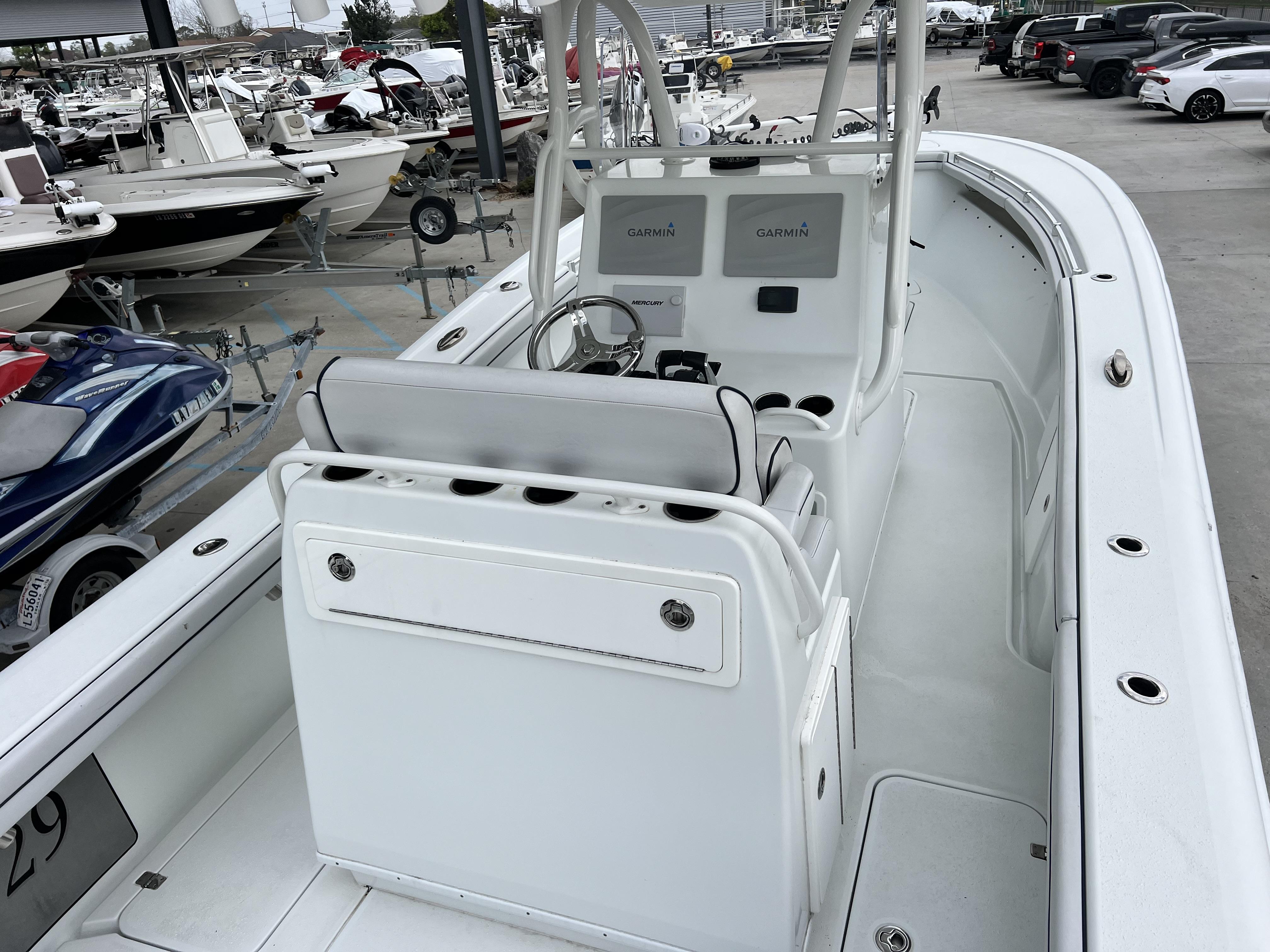 Slide: The Image of 2018 Yellowfin 29 boat interior with dual Garmin displays, docked among other boats. - 20