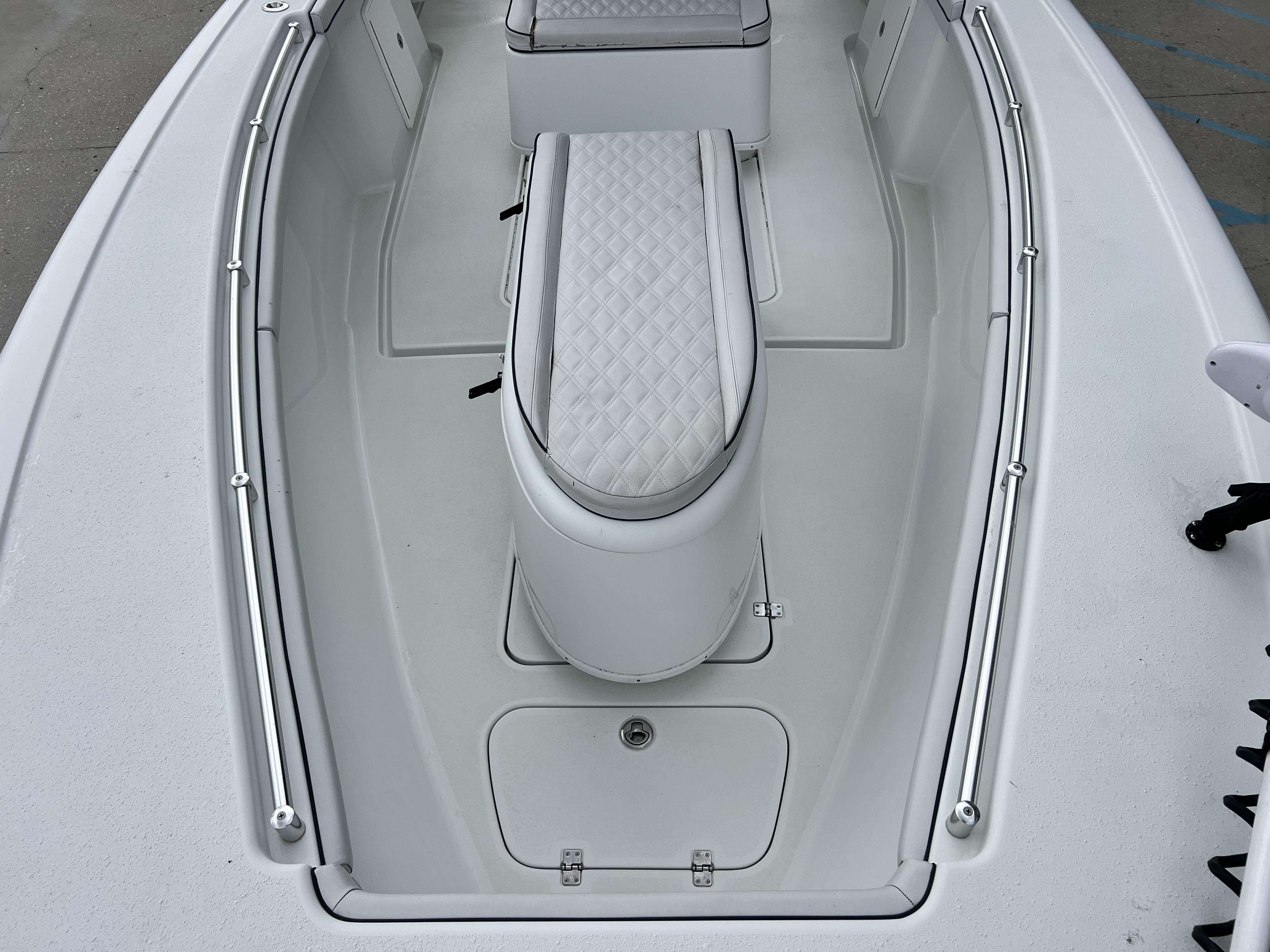Slide: The Image of 2018 Yellowfin 29 boat interior with white cushioned seating and storage compartments. - 8